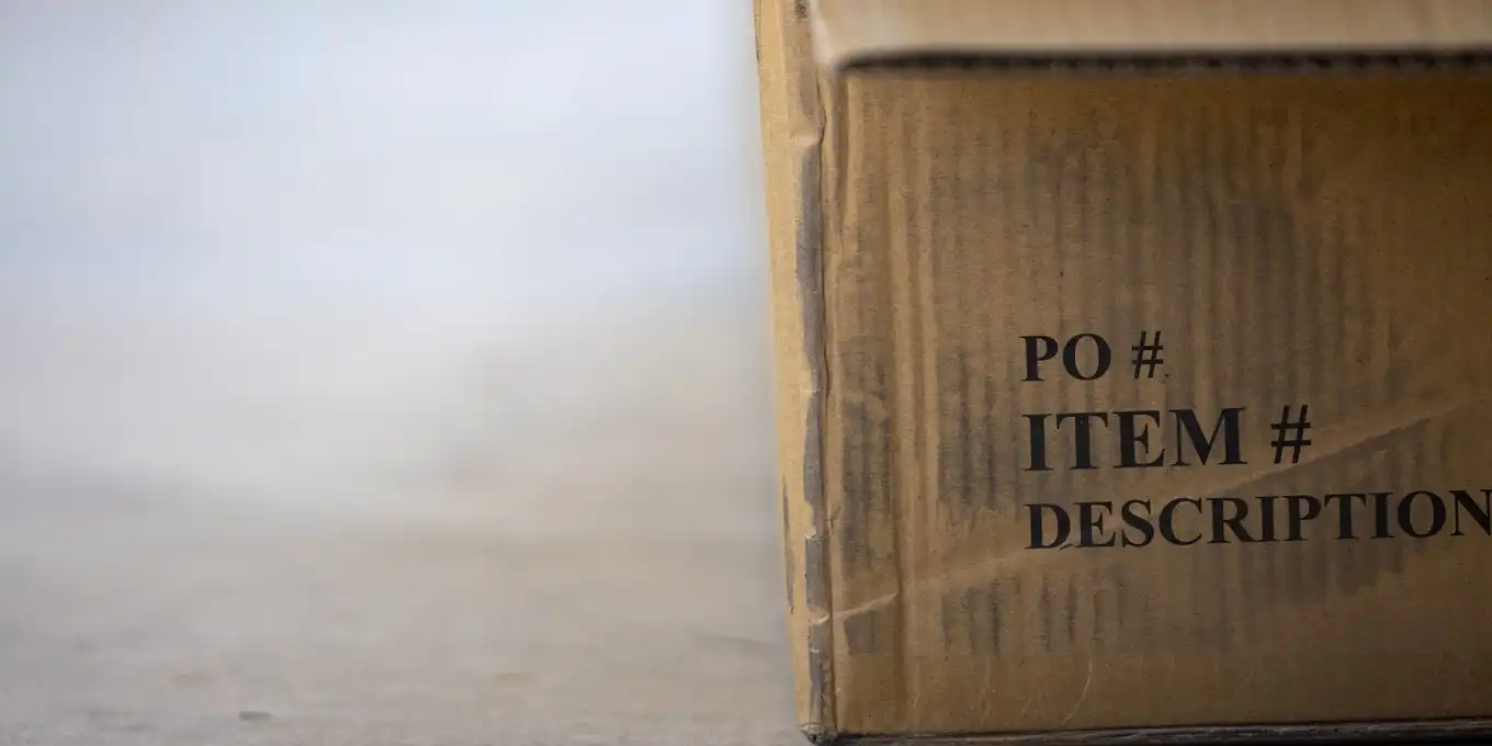 A brown cardboard shipping box on a grey floor
